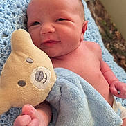Henry is registered to the contest to win money with this photo: newborn, baby, infant, plush_toy, blanket, blue, smile, cute, soft, skin, hand, face, lying_down, comfort, cozy, teddy_bear, knit, portrait, child, indoors