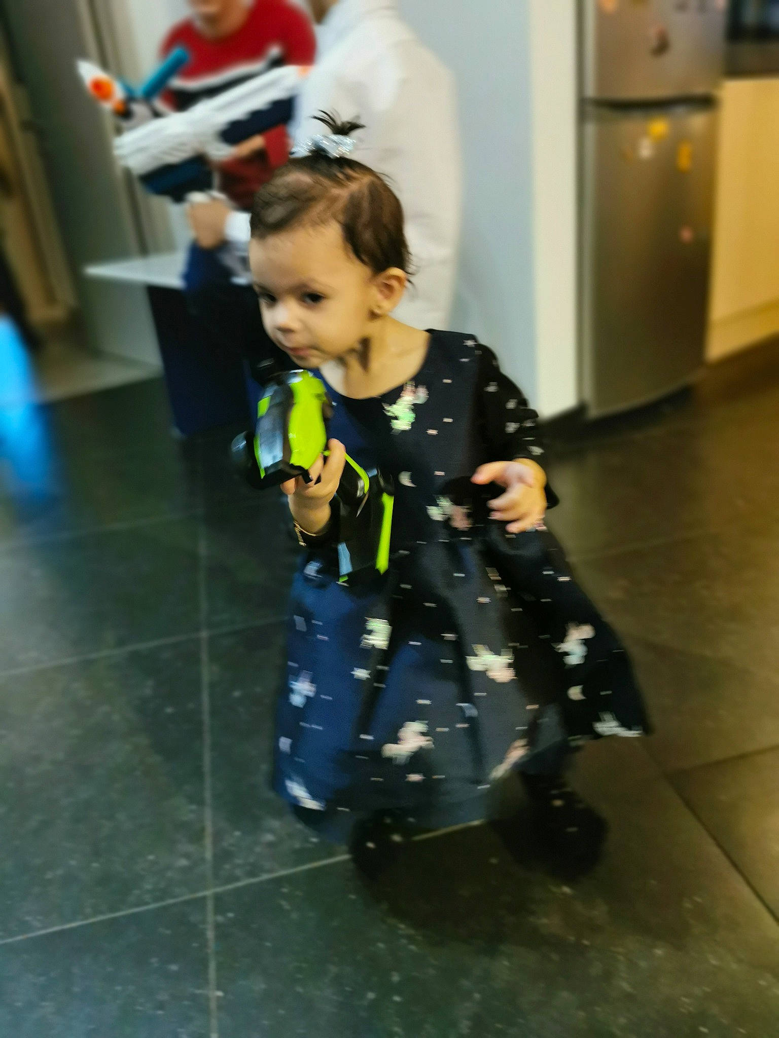 Leanna participe au concours pour gagner de l'argent avec cette photo : baby, baby_toddler_clothing, child, day_dress, entertainment, event, fashion_design, floor, flooring, formal_wear, fun, human_leg, leisure, one_piece_garment, pattern, performing_arts, person, sandal, sleeve, standing