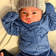 Malakai joined the competition — help win amazing prizes! baby, infant, child, blue_onesie, shark_pattern, knit_hat, cozy, blanket, cute, portrait, newborn, soft_texture, sleepwear, warm_clothing, closeup, face, hand, lying_down, indoors, adorable