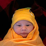 Matthew is registered to the contest to win money with this photo: baby, infant, swaddled, blanket, hat, orange, face, cute, newborn, wrapped, child, person, headwear, cozy, portrait, indoors, soft, expression, warm, smile