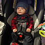 Matthew joined the competition — help win amazing prizes! baby, car_seat, blue_hat, pom_poms, red_plaid_shirt, black_pants, red_shoes, seatbelt, child, indoors, cute, infant, clothing, sitting, person, footwear, hat, safety, young_child, car_seat_toys