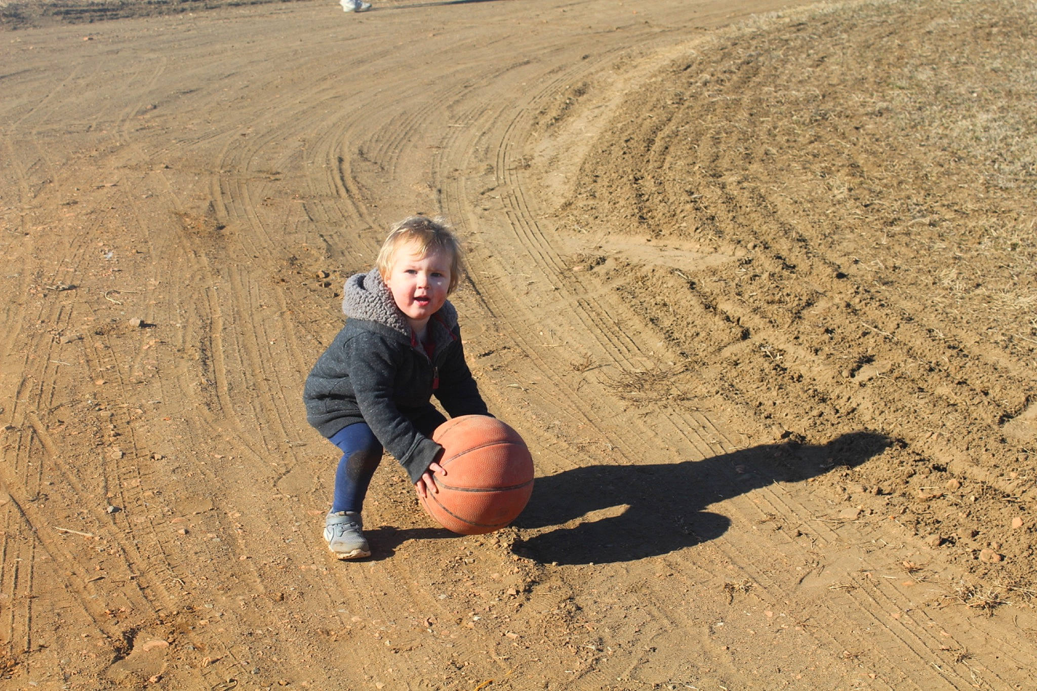 Charlie is registered to the contest to win money with this photo: aeolian_landform, ball, basketball, football, fun, grass, happy, landscape, people_in_nature, people_on_beach, person, play, recreation, sand, shadow, singing_sand, sitting, smile, soil, sports_equipment