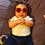 baby, child, sunglasses, toy, blanket, quilted, clothing, hands, indoor, cute, infant, relaxed, person, portrait, funny, accessory, colorful, soft, babywear, casual
