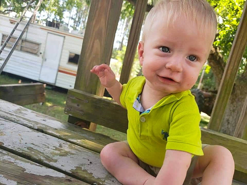 Brently is registered to the contest to win money with this photo: child, finger, hand, person, play, sitting, smile, thumb, toddler, vacation, wood