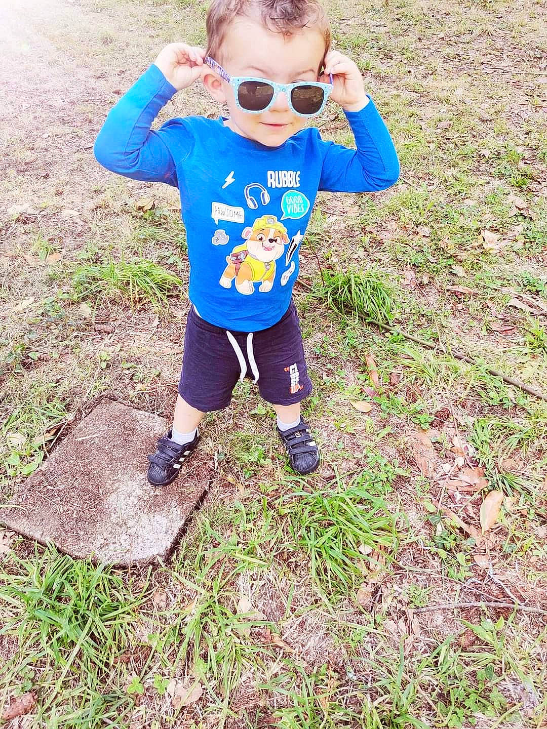 Melvin participe au concours pour gagner de l'argent avec cette photo : baby, baby_toddler_clothing, boot, electric_blue, eyewear, fun, goggles, grass, grassland, happy, pattern, people_in_nature, person, personal_protective_equipment, recreation, sleeve, soil, sunglasses, t_shirt, toddler