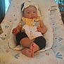 baby, infant, headband, bow, baby_seat, floral_pattern, pastel_colors, clothing, yellow_top, black_pants, feet, toes, face, hair, indoors, furniture, curtains, plant, table, wooden_chair