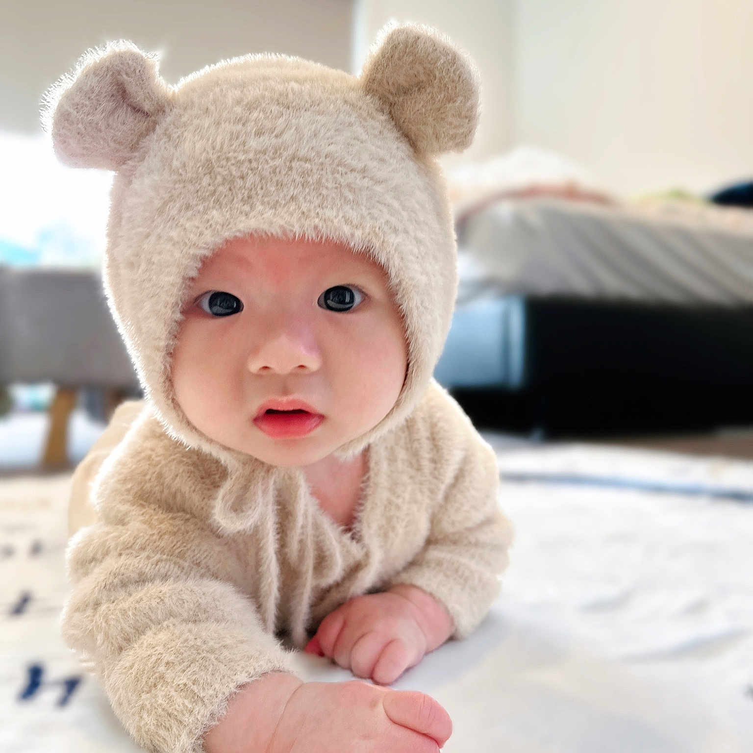 Gabriel joined the competition — help win amazing prizes! baby, bear_hat, bedroom, blanket, child, cozy, curious, cute, cute_outfit, face, fluffy, hand, indoors, infant, lying_down, onesie, portrait, soft_texture, warm, wide_eyes
