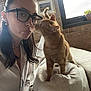 Duck is registered to the contest to win money with this photo: brick_wall, casual, cat, couch, cozy, curious, earrings, feline, glasses, home, indoor, natural_light, orange_tabby, pet, plant, portrait, puckered_lips, white_shirt, window, woman