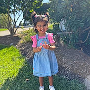 Anshika joined the competition — help win amazing prizes! child, girl, smiling, outdoor, sunlight, grass, trees, pink_clothing, denim_dress, pigtails, hair_accessories, white_shoes, happy, nature, daylight, portrait, young_child, standing, casual_clothing, playful