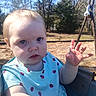 toddler, child, swing, outdoor, daylight, trees, playground, blue_eyes, short_hair, ladybug_pattern, shirt, hand, curious, face, nature, sunlight, baby, seat, expression, person