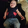 Maria is registered to the contest to win money with this photo: baby, child, infant, smiling, blue_jeans, heart_patch, navy_top, sitting, soft_fabric, blanket, clothing, casual, indoors, portrait, cute, happy, young_child, person, relaxed, comfort