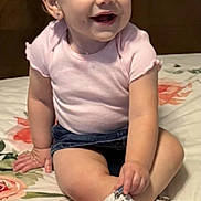 Reignlynn joined the competition — help win amazing prizes! baby, child, smiling, headband, bow, pink_shirt, denim_shorts, white_sneakers, sitting, bedspread, floral_pattern, cute, indoors, happy, small_child, portrait, playful, person, footwear, headwear