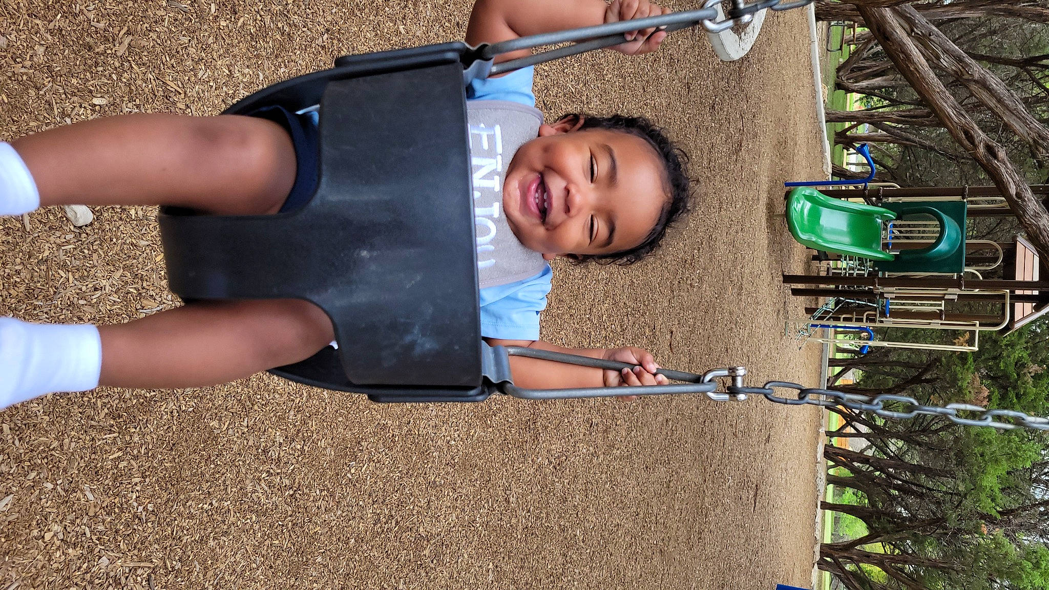 Armani is registered to the contest to win money with this photo: baby_toddler_clothing, child, city, fun, grass, happy, human_settlement, joy, leisure, light, outdoor_play_equipment, people, person, play, product, public_space, recreation, shorts, smile, t_shirt