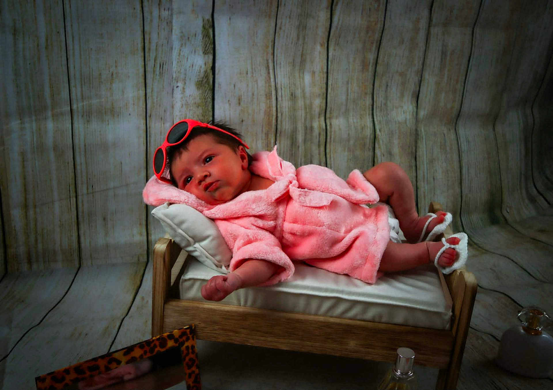 Soline a rejoint le concours — aidez-le/la à gagner de superbes lots ! baby, infant, pink_robe, sunglasses, wooden_bed, pillow, feet, hand, face, wooden_floor, wooden_wall, blanket, sleepwear, indoors, portrait, cute, relaxing, small_bed, fashion, cozy