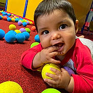 Lucas joined the competition — help win amazing prizes! baby, child, play_area, colorful_balls, red_carpet, yellow_ball, green_ball, blue_ball, purple_ball, soft_toys, indoor_play, cute, smiling, hand_in_mouth, toddler, happy, close_up, casual_clothing, fun, playtime
