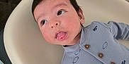 Theodore joined the competition — help win amazing prizes! baby, child, infant, onesie, face, tongue_out, curious, blue_clothing, airplane_print, cloud_print, baby_chair, indoor, carpet, table, strap, wood_furniture, cute, lying_down, portrait, soft_lighting