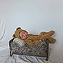 Theodore is registered to the contest to win money with this photo: baby, sleeping, knitted_outfit, bear_ears, brown_clothing, mini_bed, blanket, fur_throw, pillow, cozy, cute, infant, portrait, studio_shot, soft_lighting, white_background, peaceful, child, resting, indoors