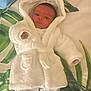 Zane is registered to the contest to win money with this photo: baby, bed, blanket, bonnet, clothing, dress, face, fashion, furniture, hat, head, hood, hoodie, knitwear, newborn, person, photography, portrait, robe, sweater