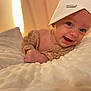 baby, infant, smiling, face, headwear, blanket, soft_texture, cozy, warm_light, indoor, cute, happy, child, portrait, laying_down, skin, clothing, hat, expression, comfort