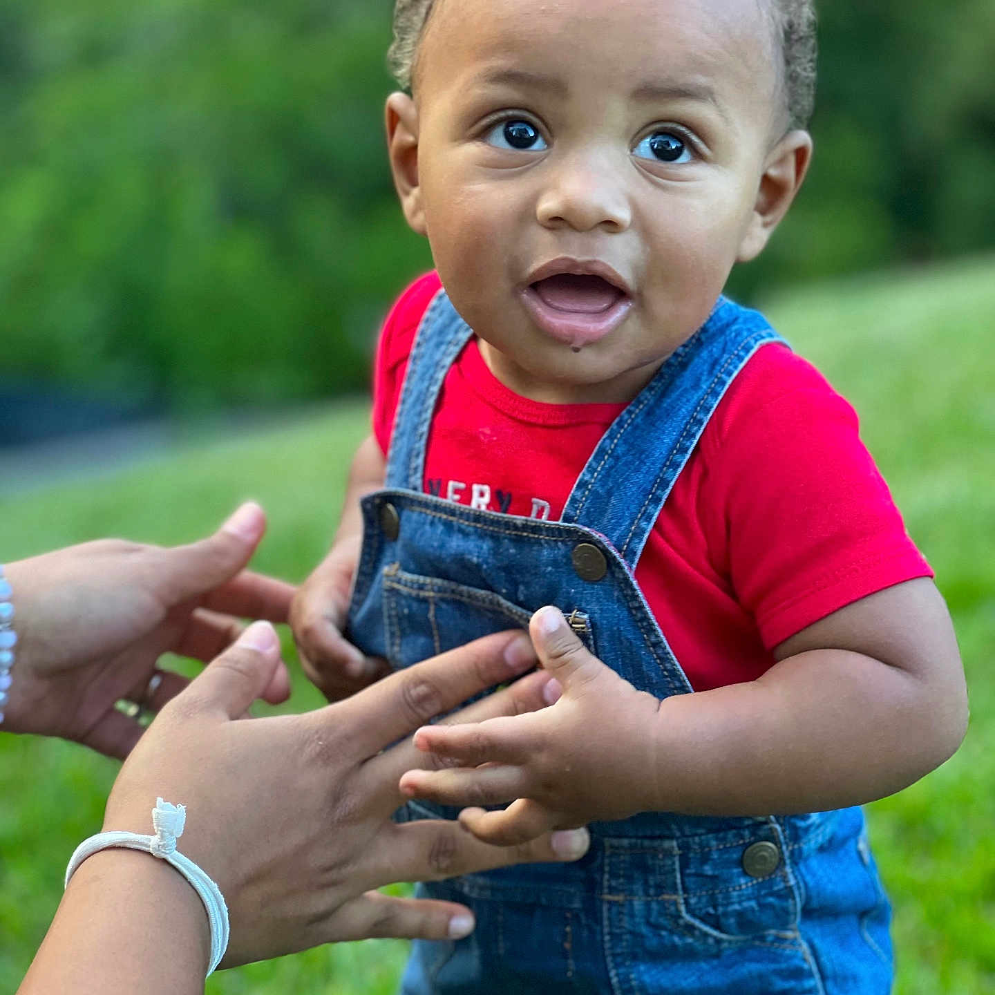Taj is registered to the contest to win money with this photo: accessories, baby, bodypart, bracelet, clothing, dress, face, finger, grass, hand, happy, head, jeans, jewelry, pants, person, photography, plant, portrait, smile