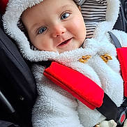 Victoire a rejoint le concours — aidez-le/la à gagner de superbes lots ! baby, child, infant, face, smile, hood, jacket, car_seat, seatbelt, toy, giraffe, striped, clothing, red, white, cute, blue_eyes, closeup, happy, portrait