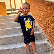 Manel a rejoint le concours — aidez-le/la à gagner de superbes lots ! child, boy, standing, barefoot, stairs, outdoor, peace_sign, smile, shorts, tshirt, pikachu, pokemon, casual_clothing, wall, railing, daylight, portrait, happy, cute, summer