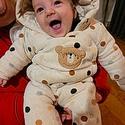 Finn joined the competition — help win amazing prizes! baby, child, smiling, happy, onesie, polka_dots, bear_patch, hooded_clothing, indoor, person_holding, red_clothing, face, expression, warm_clothing, floor, wooden_floor, infant, cute, portrait, cozy