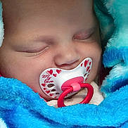 Célia participe au concours pour gagner de l'argent avec cette photo : baby, sleeping, pacifier, blue_blanket, closeup, infant, cute, face, newborn, soft_texture, cozy, wrapped, child, peaceful, mouth, pink, red_hearts, adorable, resting, portrait