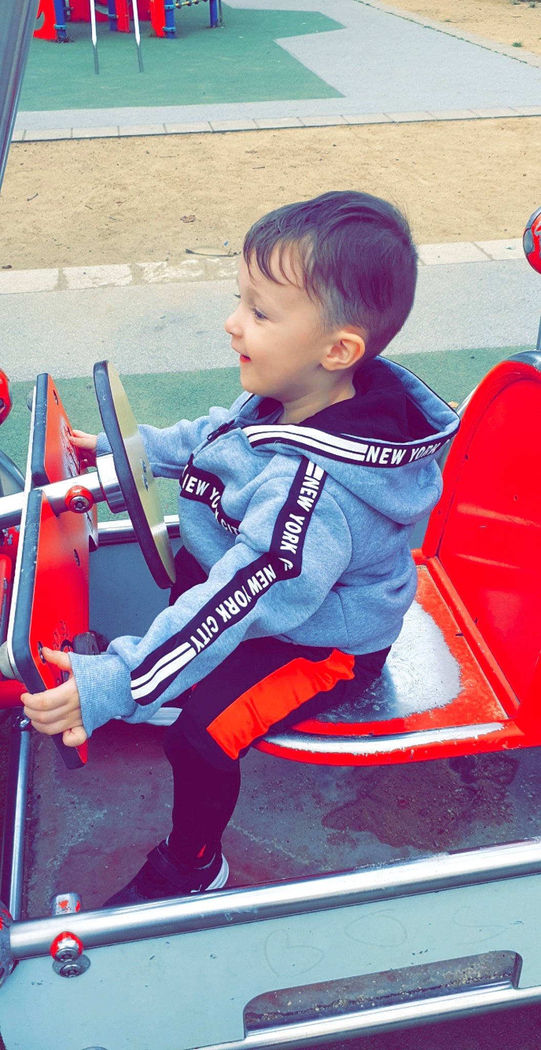 Mathéo participe au concours pour gagner de l'argent avec cette photo : automotive_exterior, baby, bumper, carmine, child, electric_blue, fun, leisure, motor_vehicle, person, personal_protective_equipment, play, recreation, red, sitting, standing, t_shirt, toddler, travel, vehicle_door