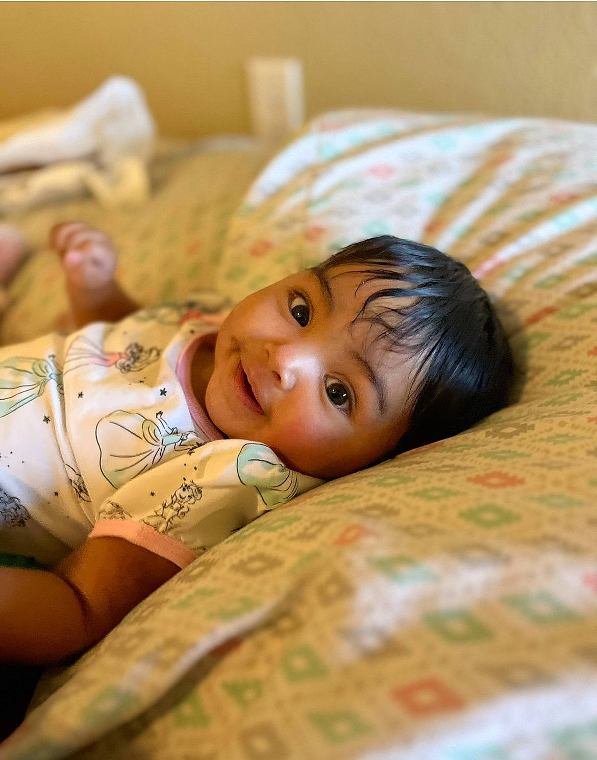 Teegan is registered to the contest to win money with this photo: abdomen, brown_hair, chest, child, comfort, elbow, eye, face, flash_photography, flooring, happy, head, human_leg, jewellery, linens, person, sitting, skin, thigh, trunk