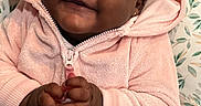 Cyanii is registered to the contest to win money with this photo: baby, child, smiling, pink_hoodie, curly_hair, indoor, portrait, happy, cute, clothing, infant, hand_gesture, patterned_background, cozy, face, sitting, earrings, baby_clothes, childhood, expression
