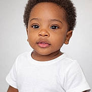 Kaiden is registered to the contest to win money with this photo: toddler, child, portrait, curly_hair, white_tshirt, face, eyes, skin, innocence, expression, young_child, person, head, cute, studio_light, background, photography, closeup, smile, baby