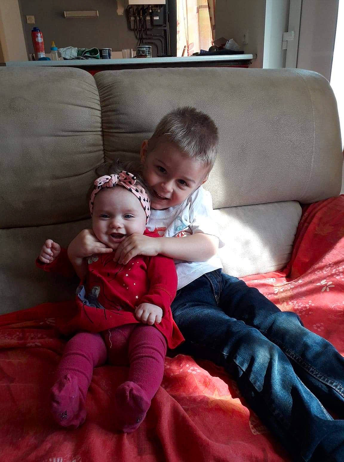 Rosalie participe au concours pour gagner de l'argent avec cette photo : baby, child, comfort, couch, daughter, fun, furniture, lap, person, sibling, sitting, skin, smile, toddler