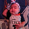 Amara joined the competition — help win amazing prizes! baby, infant, sleeping, headband, blanket, onesie, denver_broncos, hand, face, chubby_cheeks, cozy, soft_texture, resting, cute, child, portrait, indoors, comfort, relaxation, toddler
