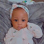 Camille is registered to the contest to win money with this photo: baby, infant, headband, onesie, blanket, face, person, clothing, cute, indoors, portrait, child, sleepwear, soft, young, newborn, lying_down, expression, closeup, adorable