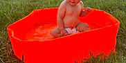 Eevy a rejoint le concours — aidez-le/la à gagner de superbes lots ! baby, child, pool, water, orange, grass, outdoor, summer, nature, diaper, sitting, backyard, fence, tree, sunlight, playing, cute, infant, fun, relaxing