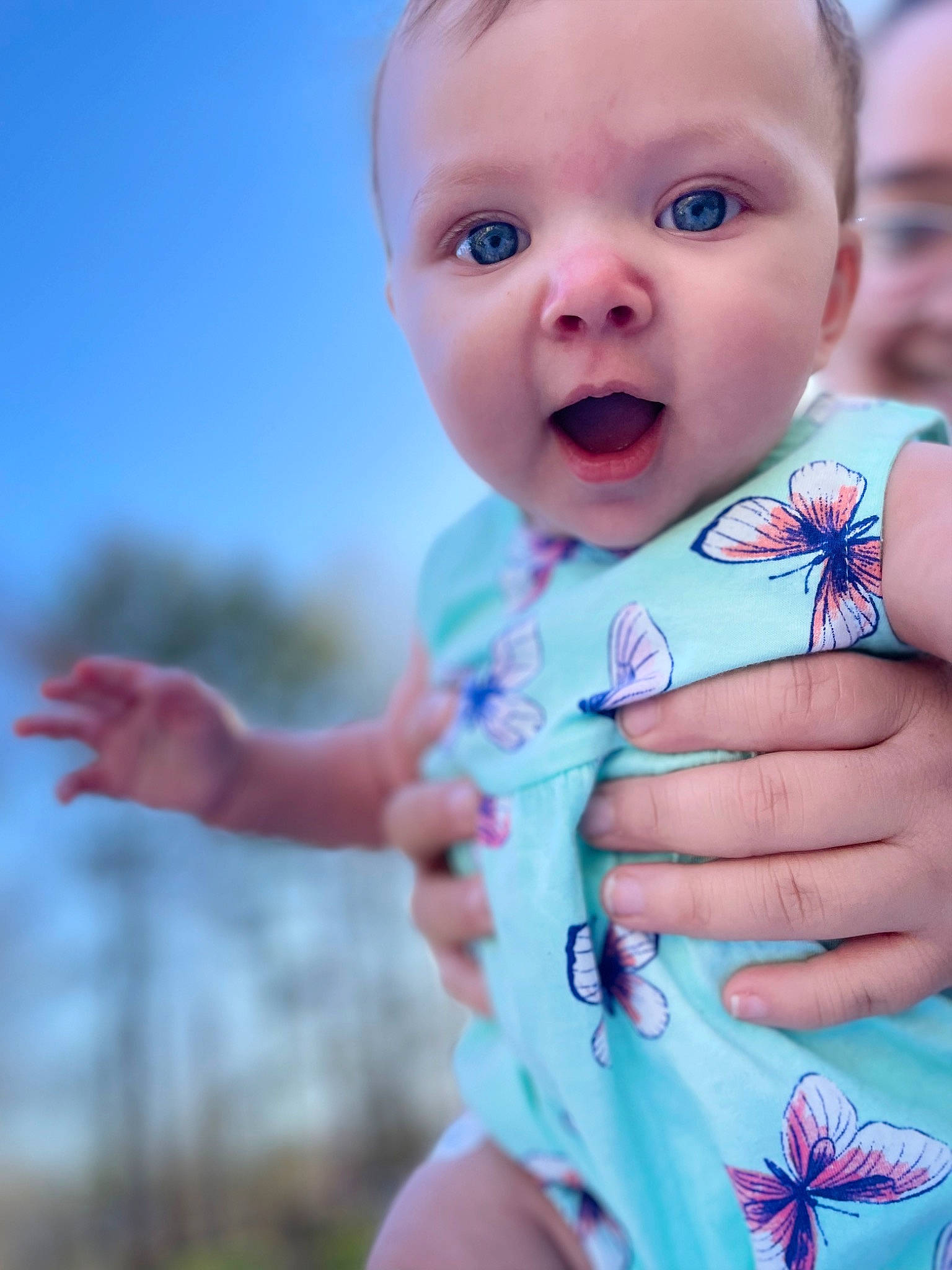 Kailani is registered to the contest to win money with this photo: azure, baby, baby_toddler_clothing, blue, cheek, face, finger, gesture, grass, hand, happy, head, lip, person, pink, skin, sky, smile, summer, surprise