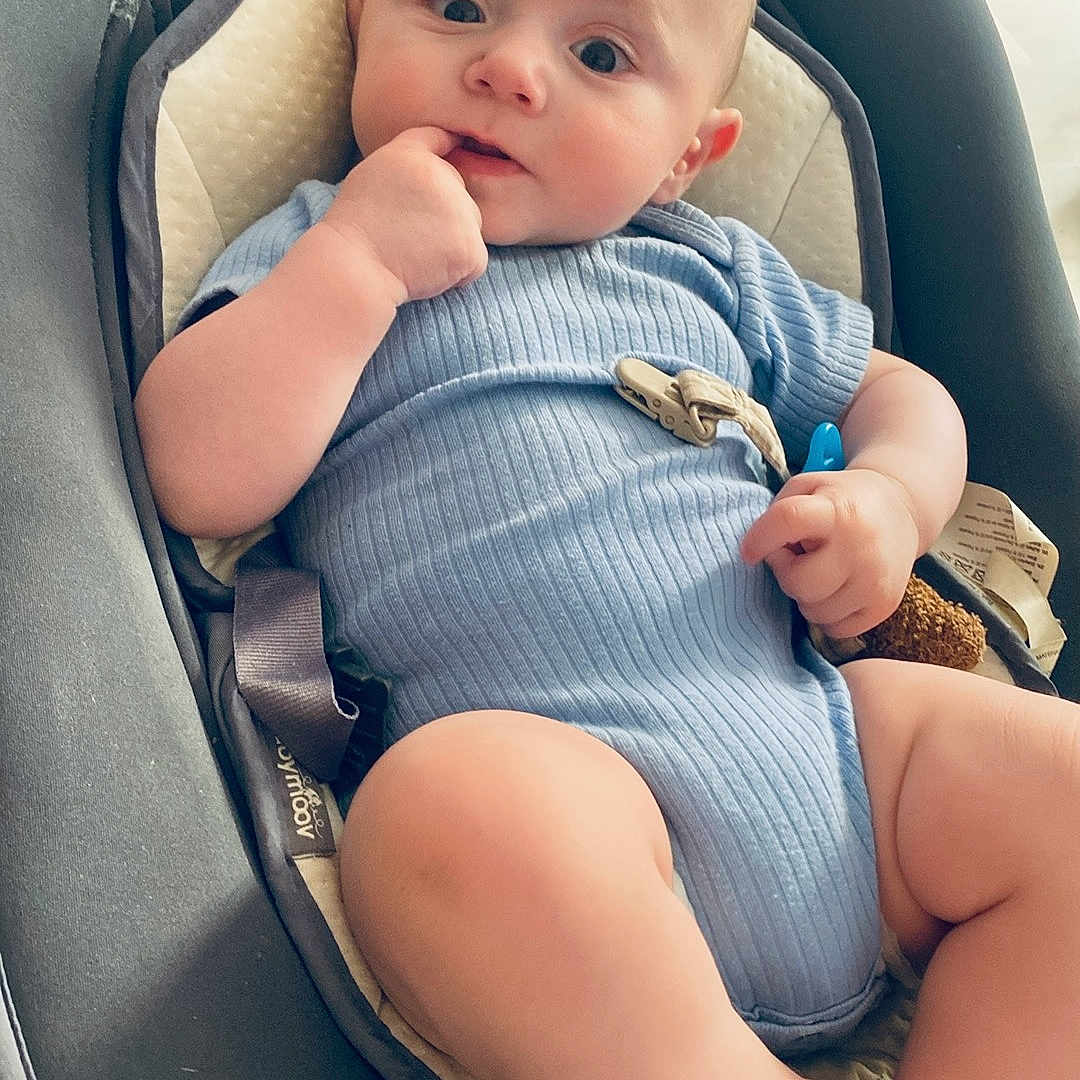 Ezio participe au concours pour gagner de l'argent avec cette photo : baby, baby_seat, blue_onesie, child, comfort, curious, cushion, cute, face, foot, hand, home, indoor, infant, legs, looking, person, sitting, soft, young