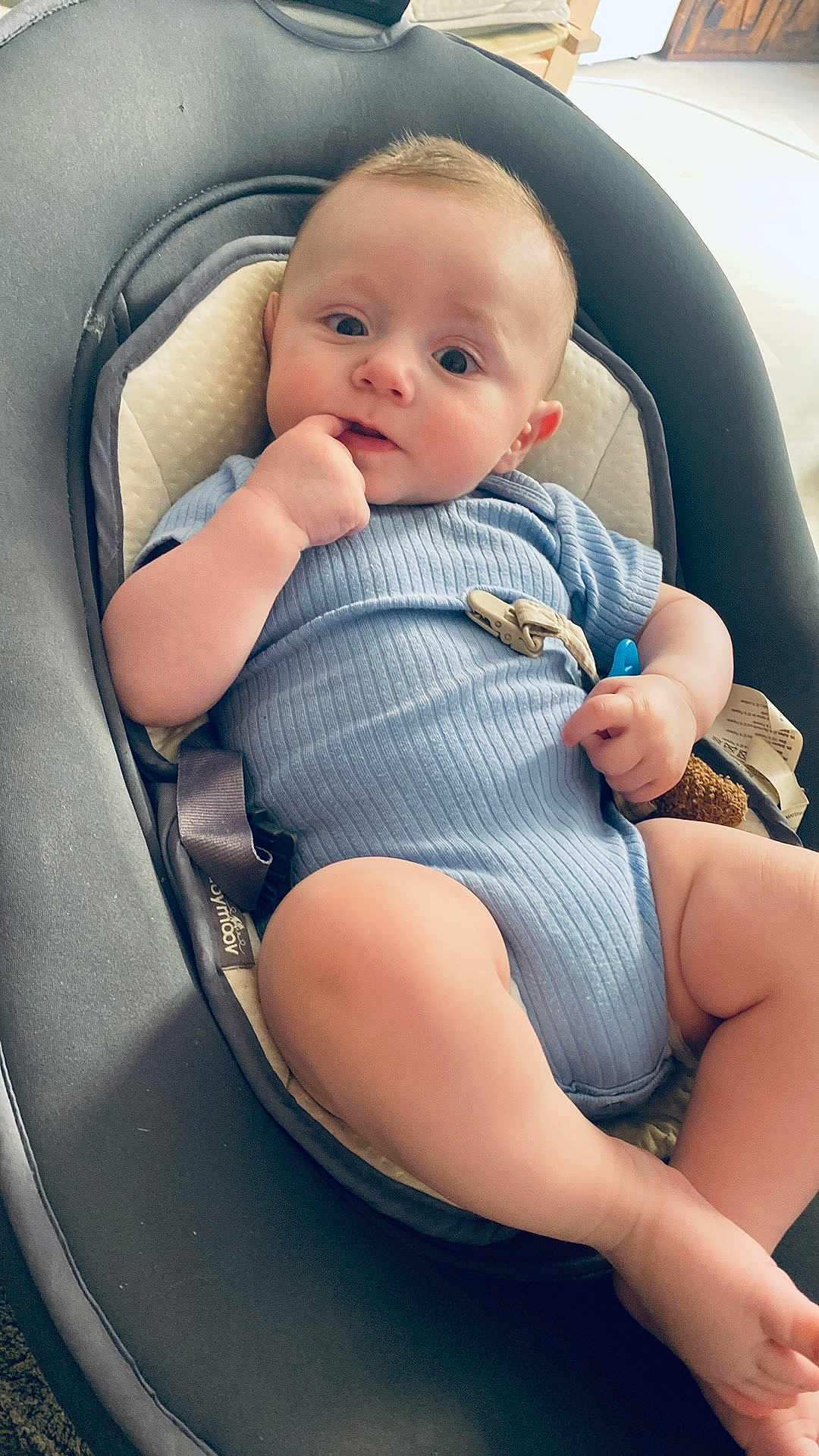 Ezio participe au concours pour gagner de l'argent avec cette photo : baby, infant, blue_onesie, baby_seat, cushion, hand, face, legs, foot, indoor, curious, child, comfort, soft, home, person, sitting, looking, cute, young
