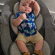 Sebastian joined the competition — help win amazing prizes! baby, child, infant, seat, clothing, shirt, shorts, shoes, footwear, indoor, cushion, gray, blue, floral_pattern, pose, hand_gesture, cute, person, face, expression
