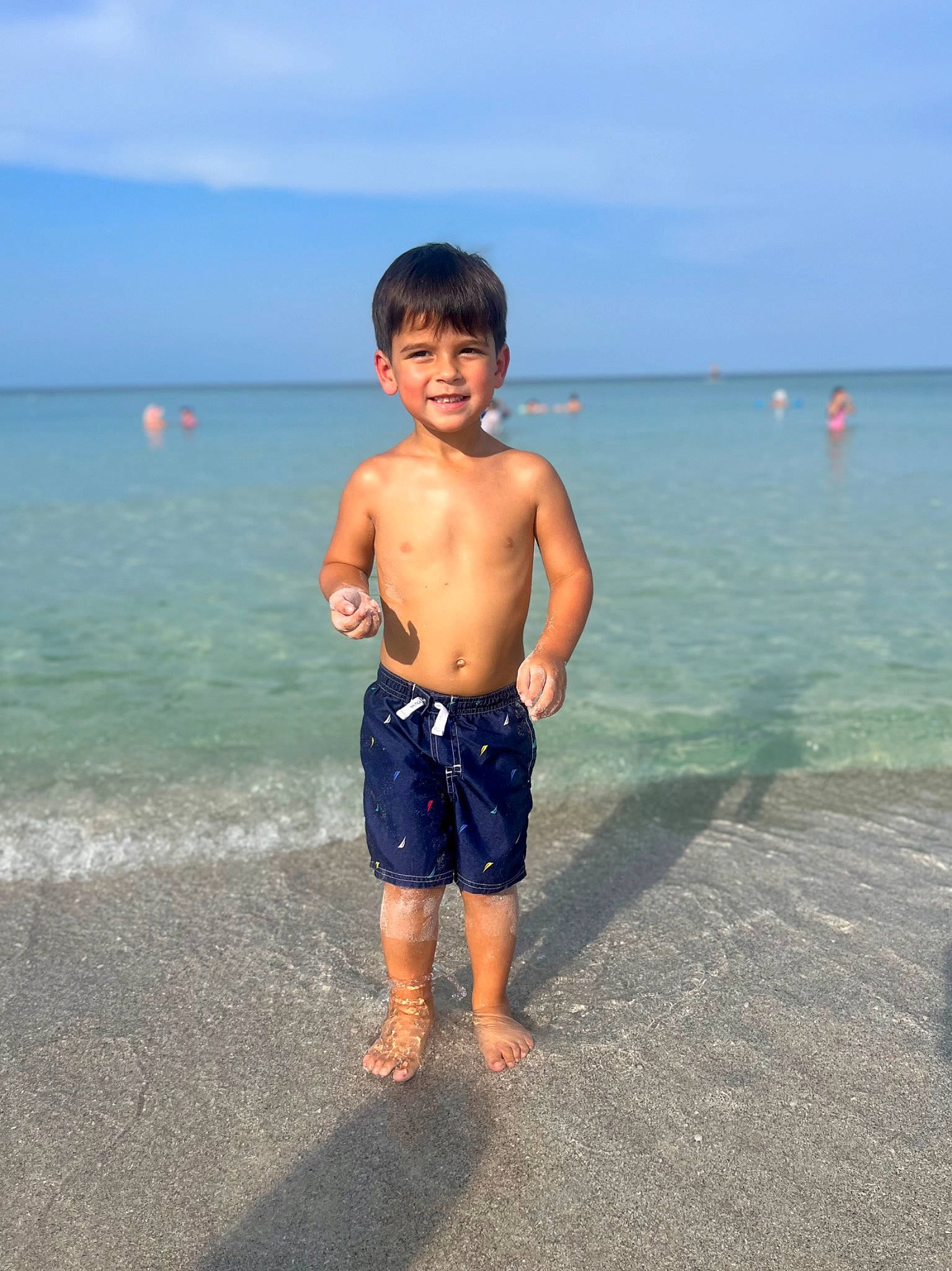 Alexander is registered to the contest to win money with this photo: barefoot, beach, bermuda_shorts, board_short, cloud, fun, happy, holiday, joy, leisure, natural_environment, people_on_beach, person, sand, sky, smile, toddler, travel, trunk, trunks