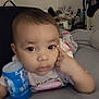 Aaliyah joined the competition — help win amazing prizes! baby, child, indoor, bed, blanket, clothing, container, curious, face, finger, furniture, holding, infant, person, portrait, sleepsuit, toddler, young_child, expression, lying_down