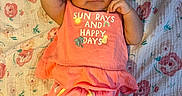 Victoria joined the competition — help win amazing prizes! baby, infant, child, floral_blanket, coral_outfit, smiling, cute, indoors, lying_down, hair_clip, text_on_clothing, skin, legs, arm, hand, fabric, pattern, comfortable, happy, portrait