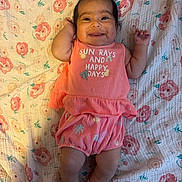 Victoria joined the competition — help win amazing prizes! baby, infant, smiling, happy, clothing, coral_outfit, blanket, floral_pattern, lying_down, cute, child, person, indoors, socks, portrait, small_hands, cheerful, skin, head, hair_clip
