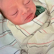 Zyel is registered to the contest to win money with this photo: newborn, baby, sleeping, swaddled, blanket, striped_blanket, face, peaceful, infant, soft_texture, closeup, skin, head, resting, cute, wrapped, young_child, portrait, indoors, cozy