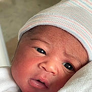 Amauri is registered to the contest to win money with this photo: baby, beanie, bonnet, cap, clothing, face, hat, head, hood, newborn, person, photography, portrait