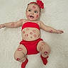 Ashly is registered to the contest to win money with this photo: baby, infant, red_clothing, headband, flower, lipstick_marks, smiling, lying_down, white_rug, cute, happy, skin, face, arms, legs, sock, playful, child, portrait, indoor