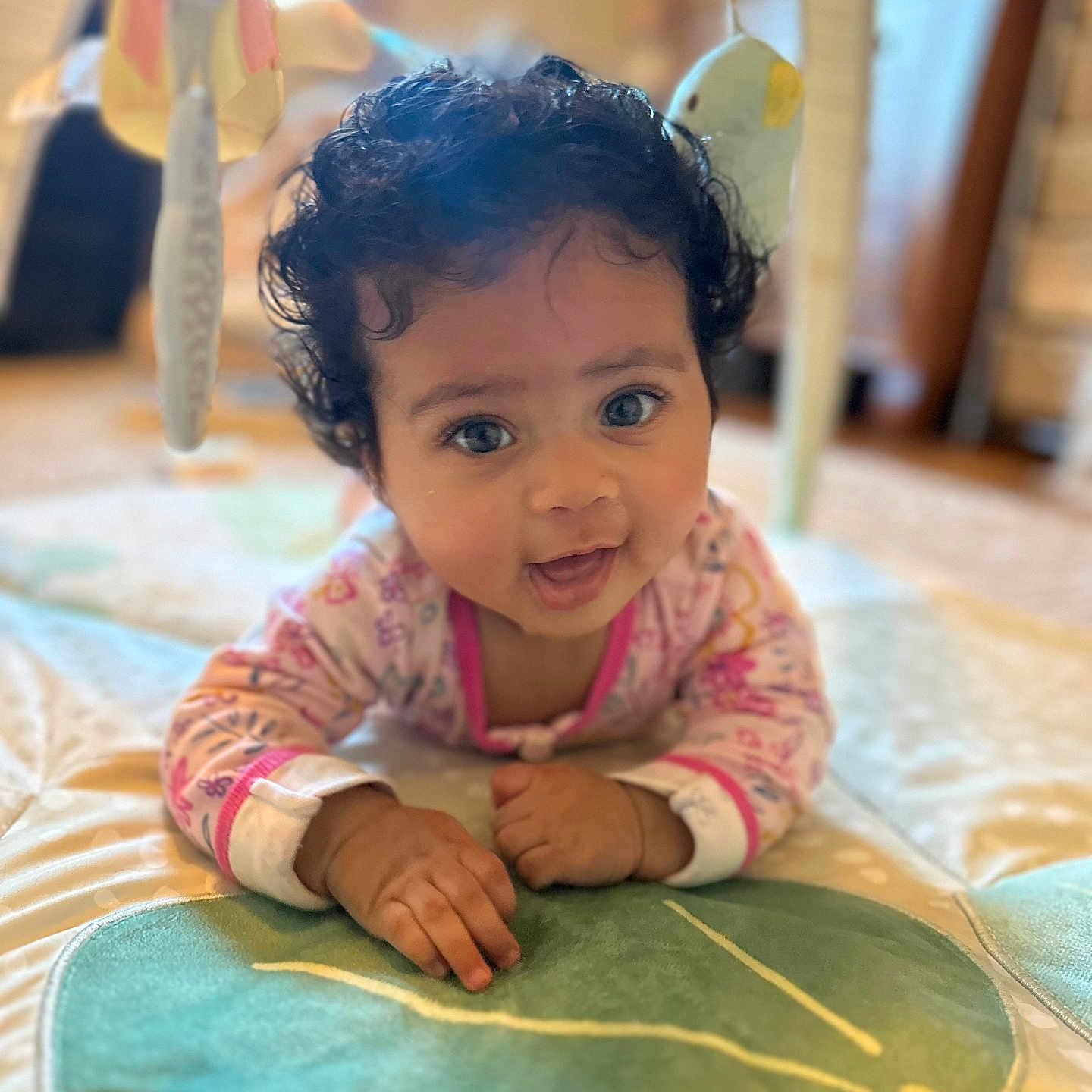 Olivia is registered to the contest to win money with this photo: baby, bodypart, child, clothing, crawling, dress, face, female, finger, furniture, girl, hand, happy, head, indoors, person, photography, portrait, smile, wood