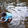 child, water, toy, duck, life_vest, playing, adult, river, floating, water_toys, outdoor, summer, puddle, reflection, person, casual, fun, nature, shallow_water, splash