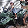 toddler, child, pacifier, hat, atv, kawasaki, outdoor, gravel, rustic, dirt, vehicle, wheel, cap, clothing, nature, trees, person, young_child, play, curious